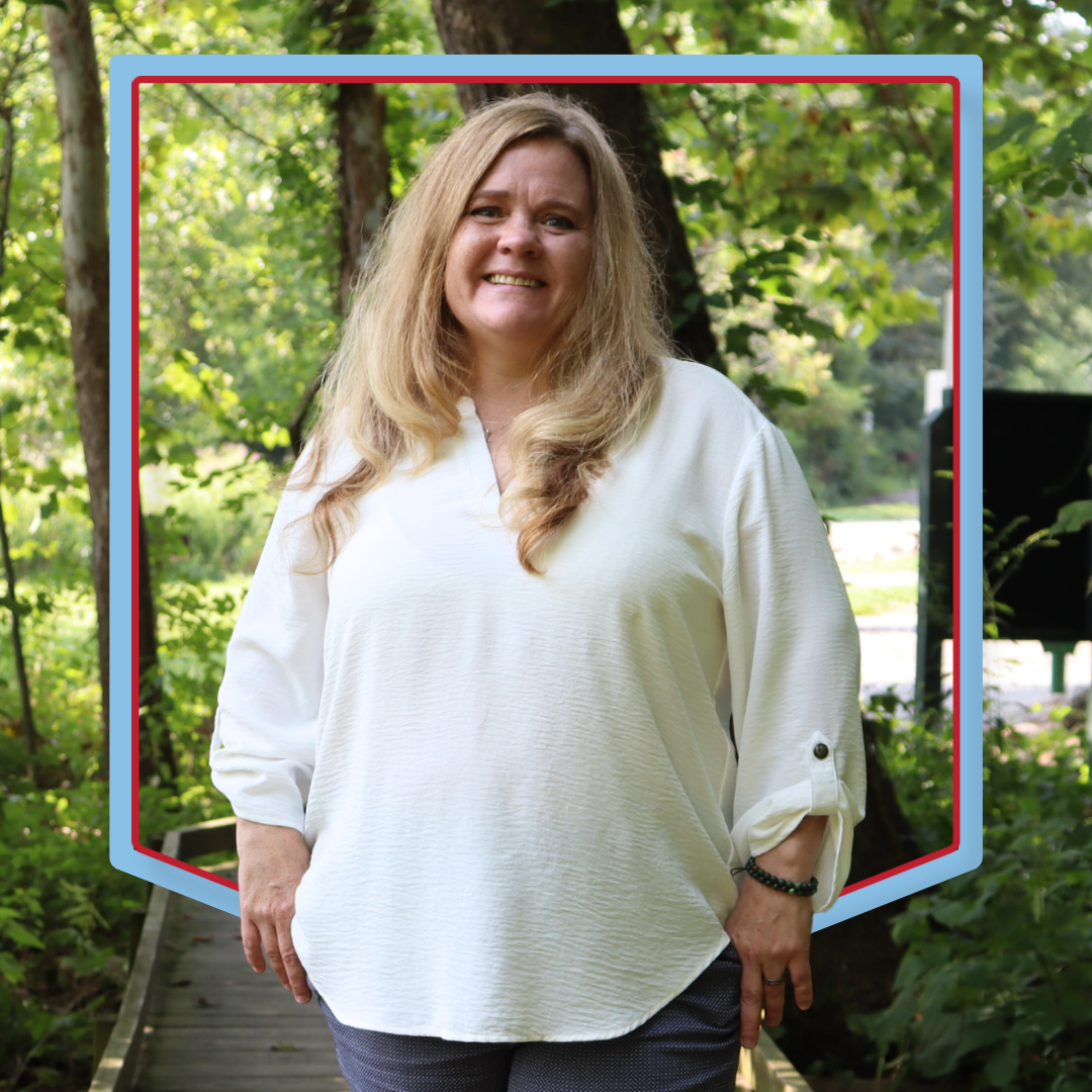 Stephanie Osborn poses in front of wooded background.